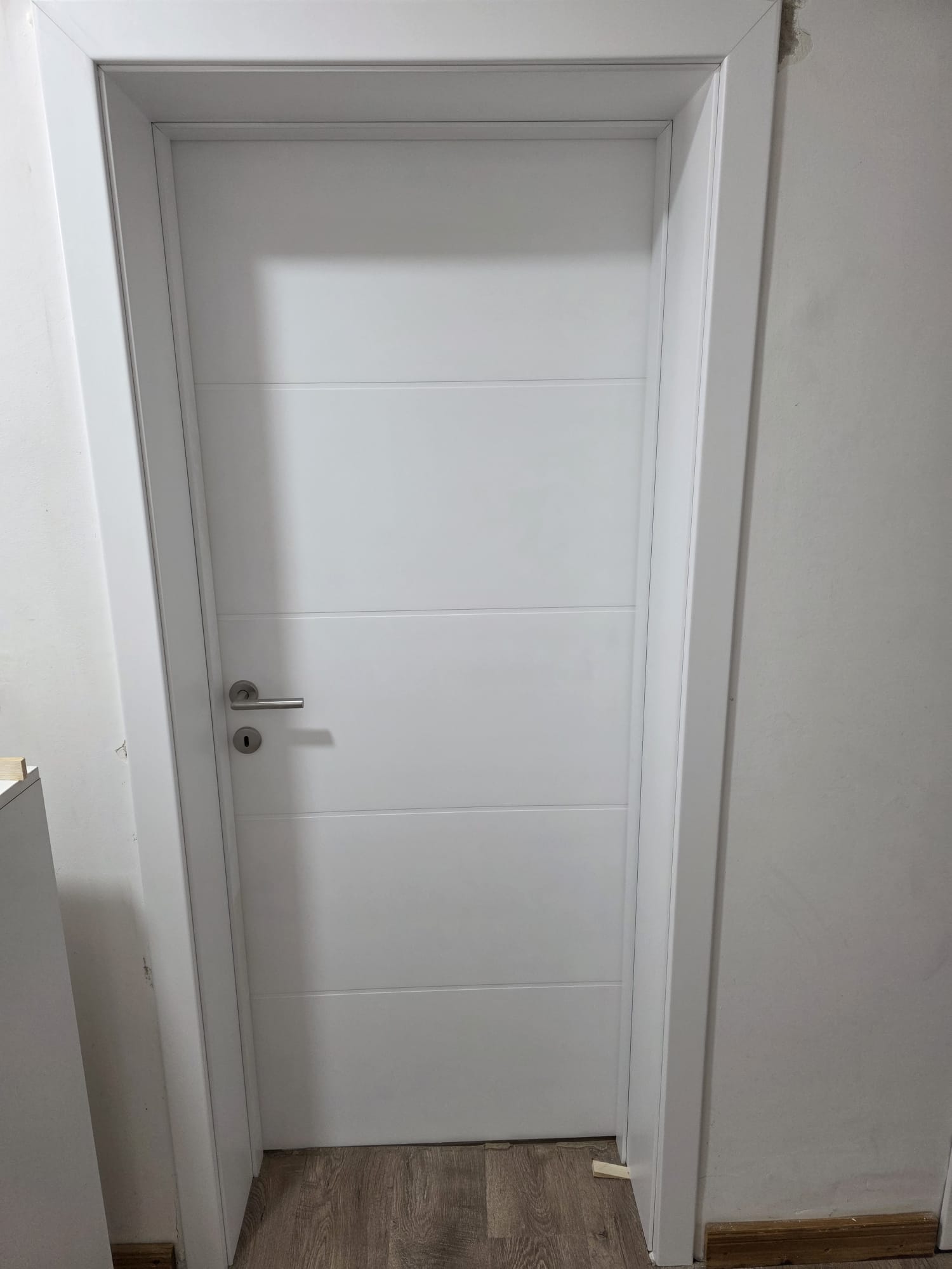 Bela farbana sobna vrata sa četiri horizontalne linije